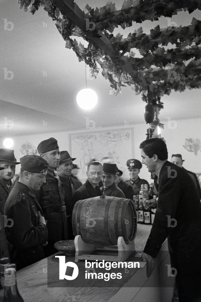 Visitors of the Leipziger Frühjahrsmesse in front of a bar with traditional drinks, Germany 1941 (b/w photo)