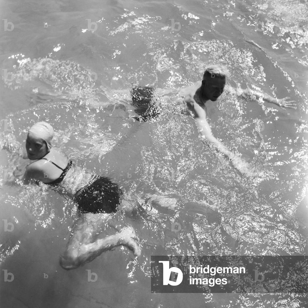 A young woman and a man swimming in a lake in the Wachau area in Austria, Germany 1930s (b/w photo)