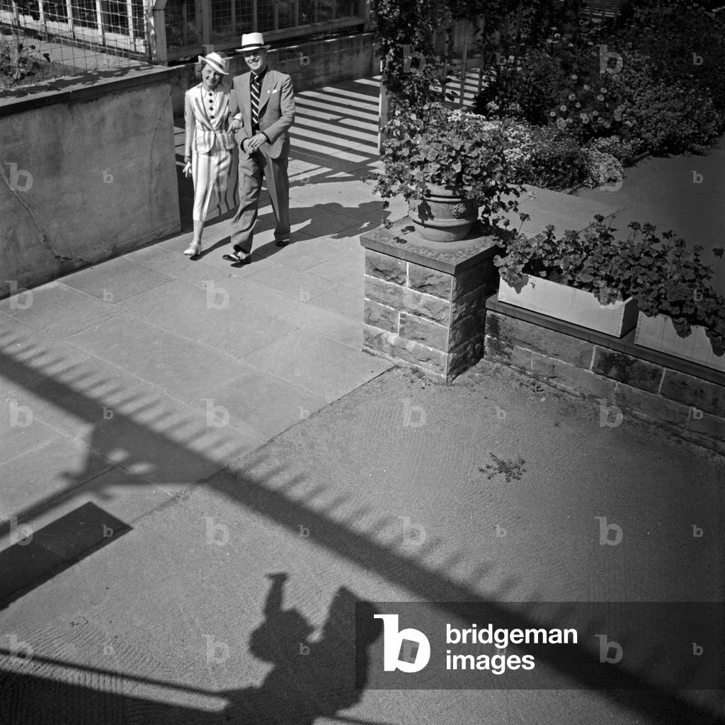A man and a woman strolling through the town of Wildbad in Black Forest, Germany 1930s (b/w photo)