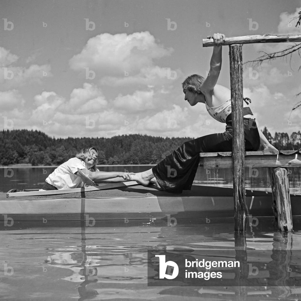 Two young women at a boardwalk on the shore of a lake in the Wachau area, Germany 1930s (b/w photo)