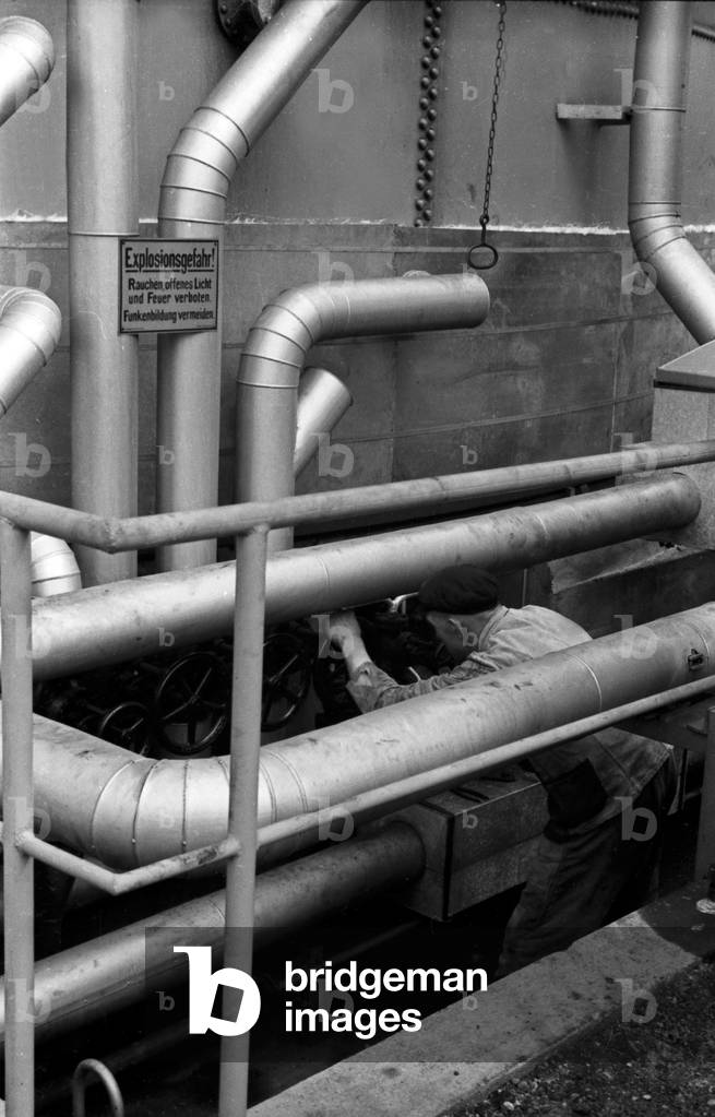Staff member at the pipelines of a silo of the Deutsche Fettsäurewerke and Maerkische Seifenindustrie company at Witten, Germany 1930s (b/w photo)