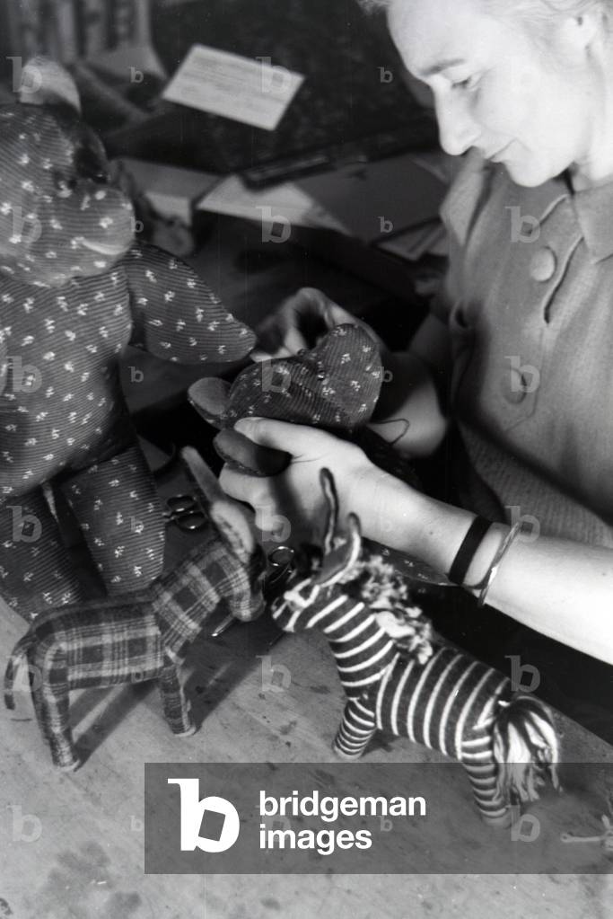 An artisan sewing cuddly toys, Germany 1930s (b/w photo)