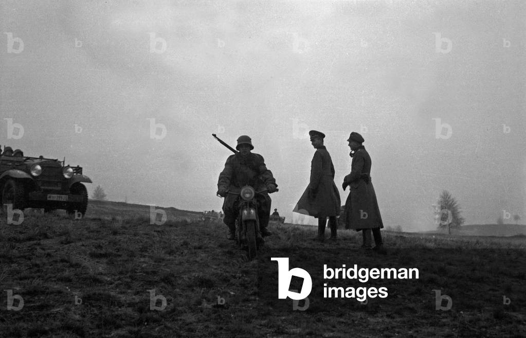 A dispatch rider leaving to officers at a military training ground, Germany 1930s (b/w photo)