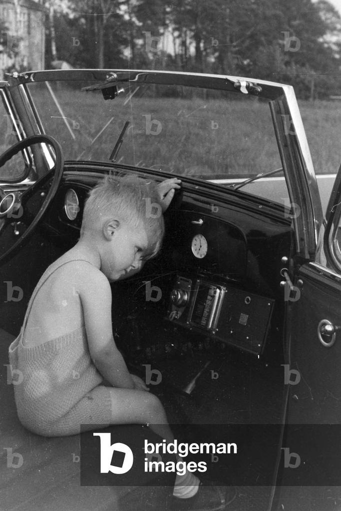 Little boy in a car, Germany 1930s (b/w photo)