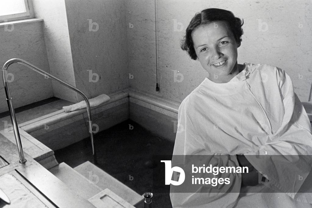 A young woman visiting the hot water pool in the Caracalla Therme in Baden-Baden, Germany 1930s (b/w photo)