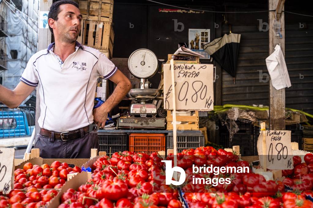 A tomatoes seller in the Capo market in Palermo, Sicily, Italy, August 2014 (photo)