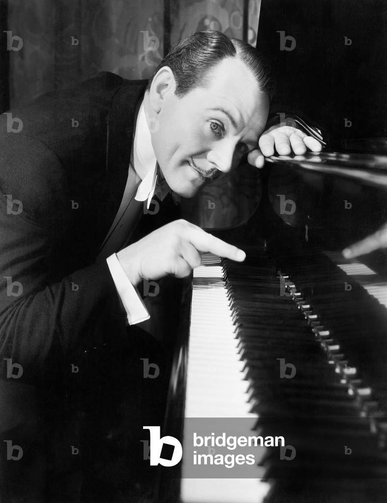 Man Leaning Over the Piano Playing the Keys with One Finger