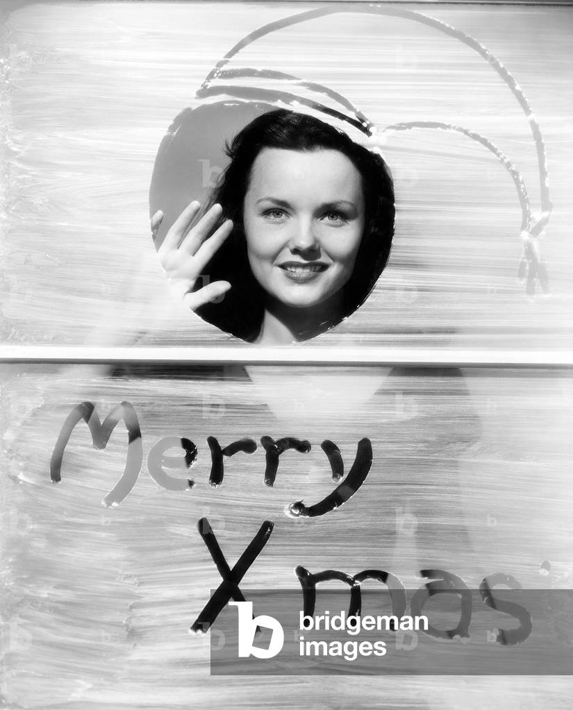 Woman Waving at Window with Christmas Greeting