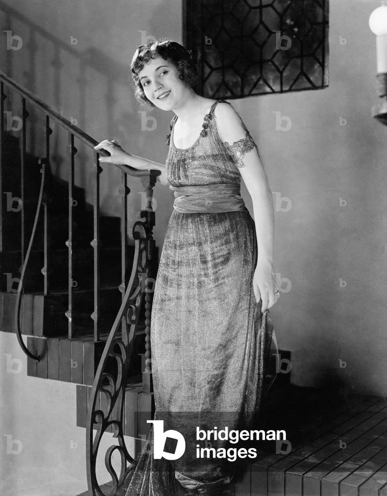 Young Woman Moving Down a Staircase and Smiling