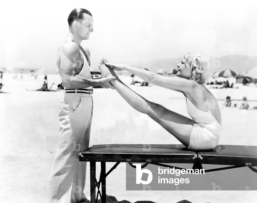 Trainer and Young Woman Doing Exercises at the Beach