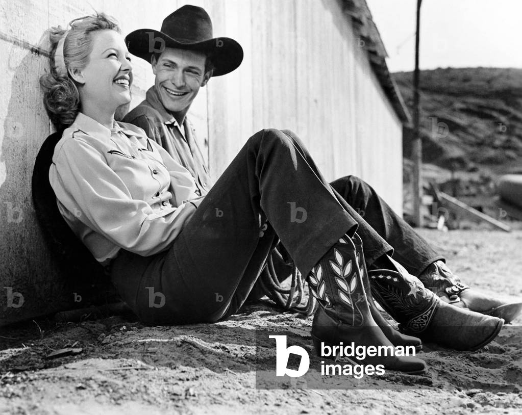 Laughing Couple in Western Attire Sitting on the Ground
