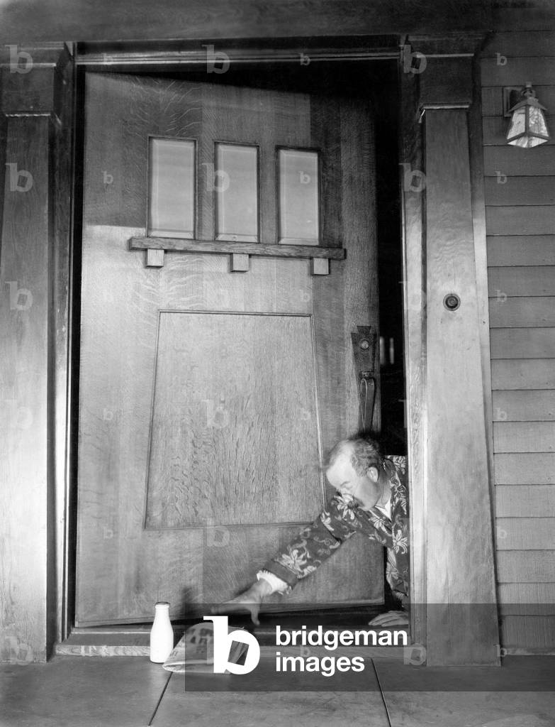 Man Crawling at the Front Door to Reach his Newspaper and Milk