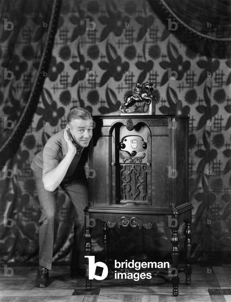 Portrait of a man listening to music from a radio and smiling (EV005598_H)