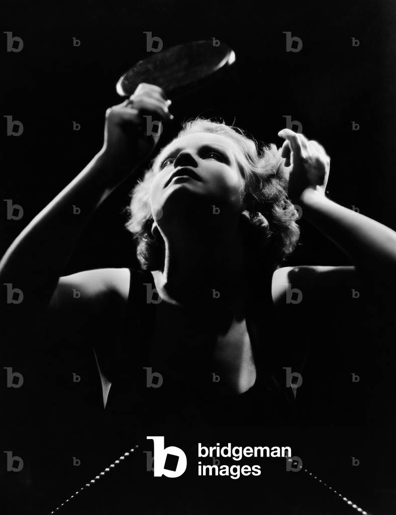 Woman Looking in Hand Mirror