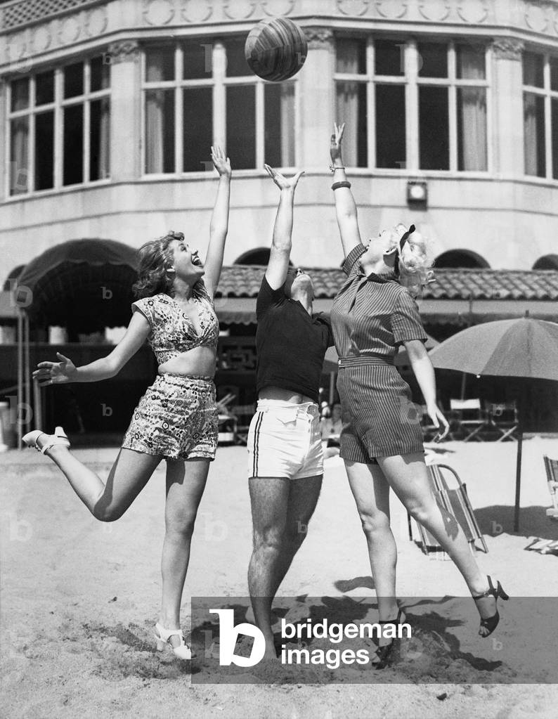 Three Young Women Playing with a Ball on the Beach