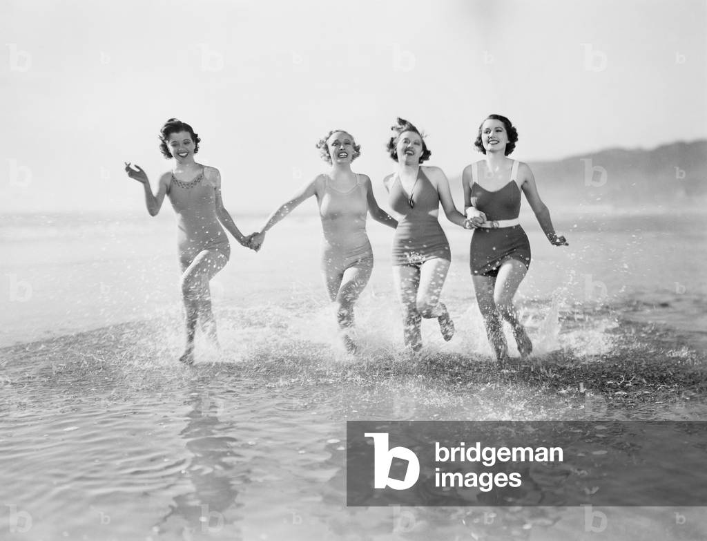 Four Women Running in Water on the Beach