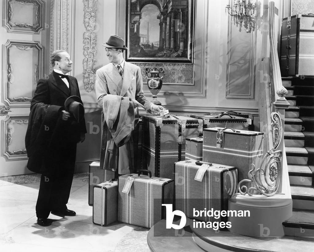 Two Men Standing in the Hallway with MaNY Suitcases