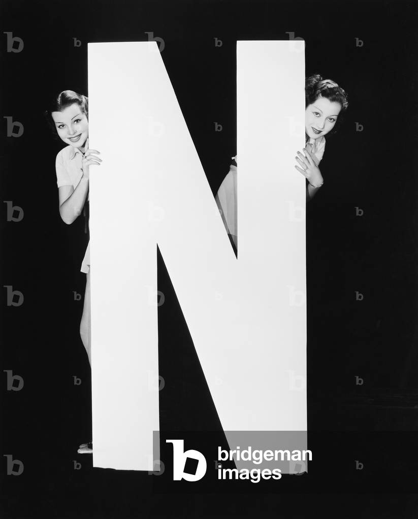 Two Women Hiding Behind Huge Letter N