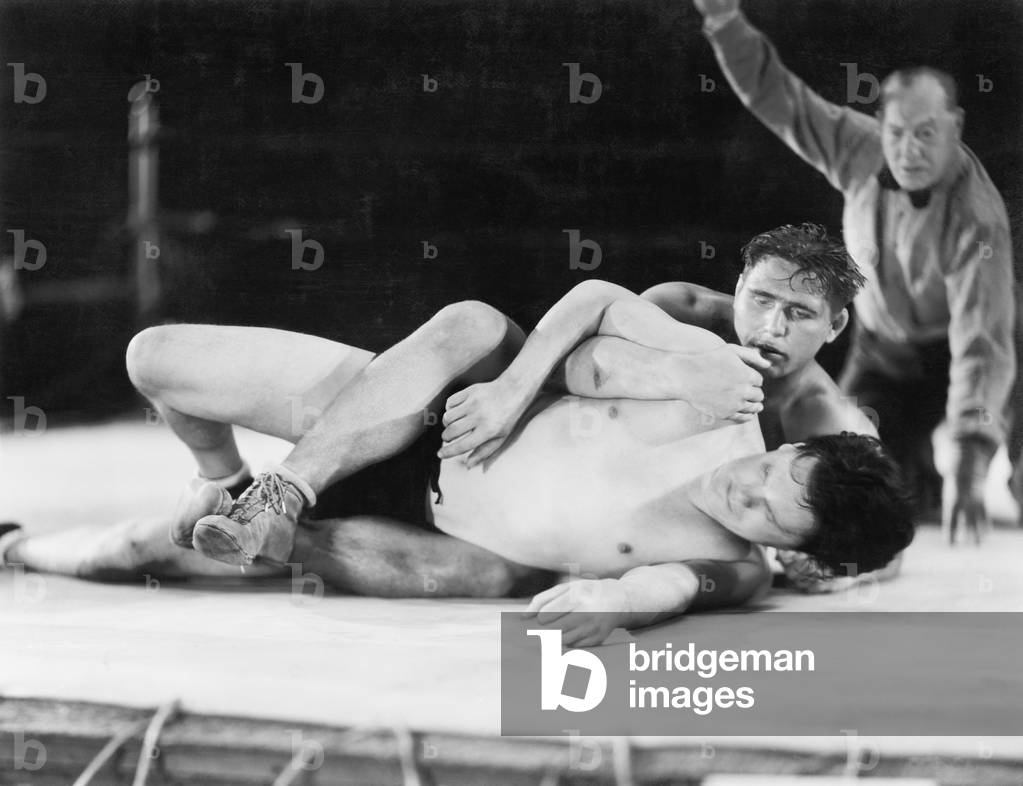 Two Men Wrestling with a Referee in the Background