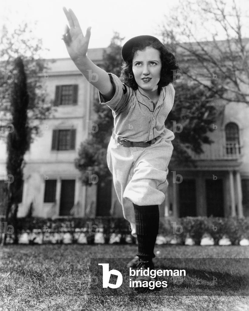 Young Woman in Baseball Uniform Throwing a Ball