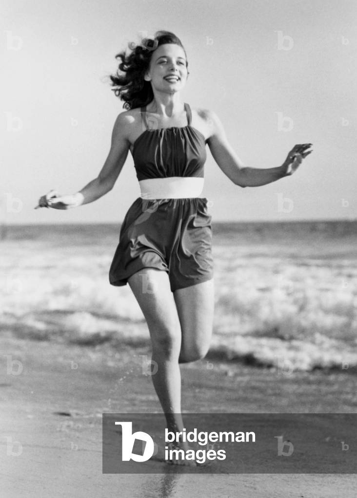 Jeune femme courant sur la plage