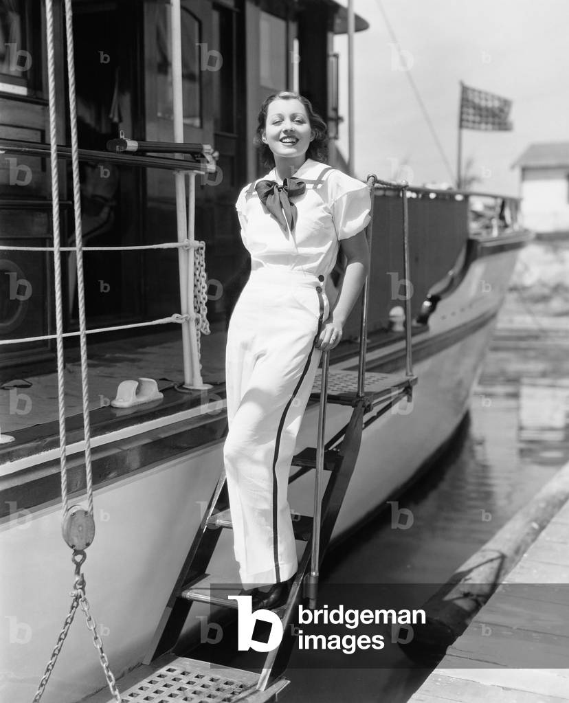 Portrait of a Young Woman Standing on Steps of a Boat and Smiling
