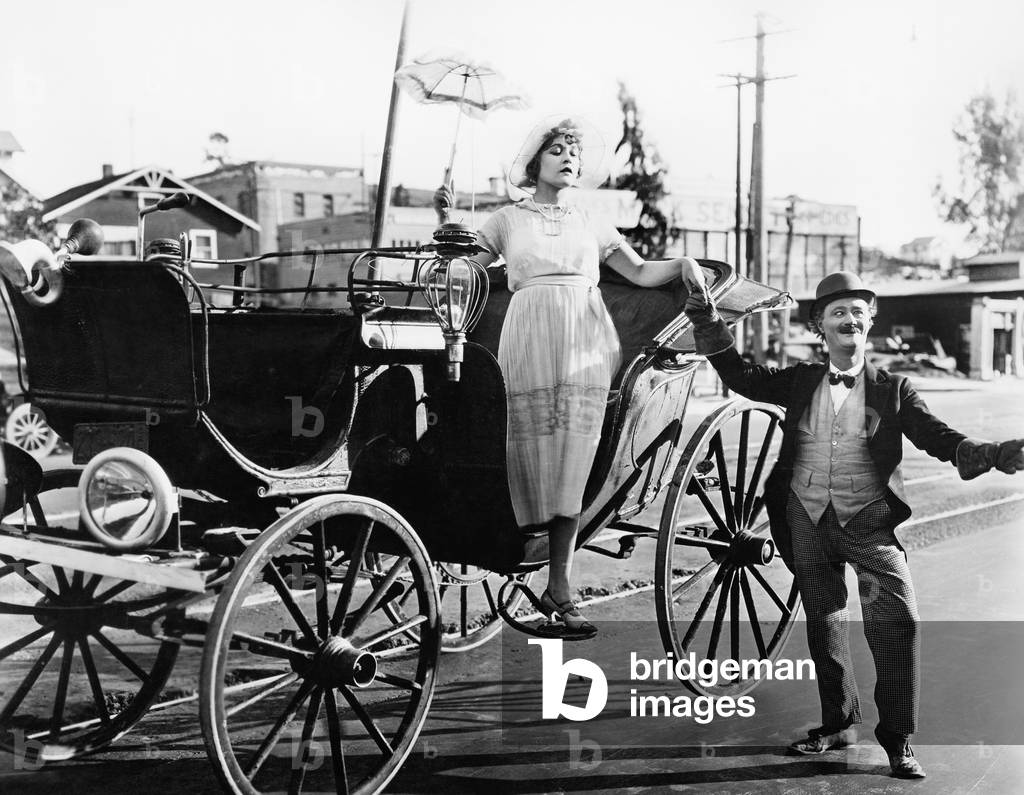 Man Helping a Woman Get Out of a Wagon