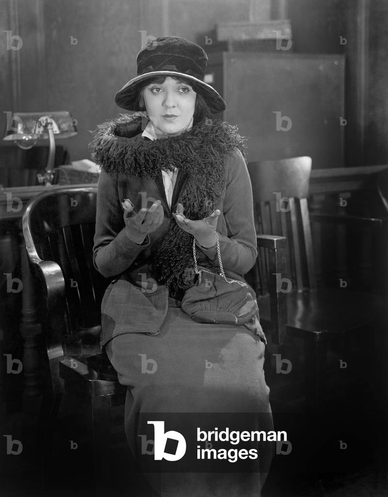 Young Woman Sitting on a Chair in an Office Trying to Explain