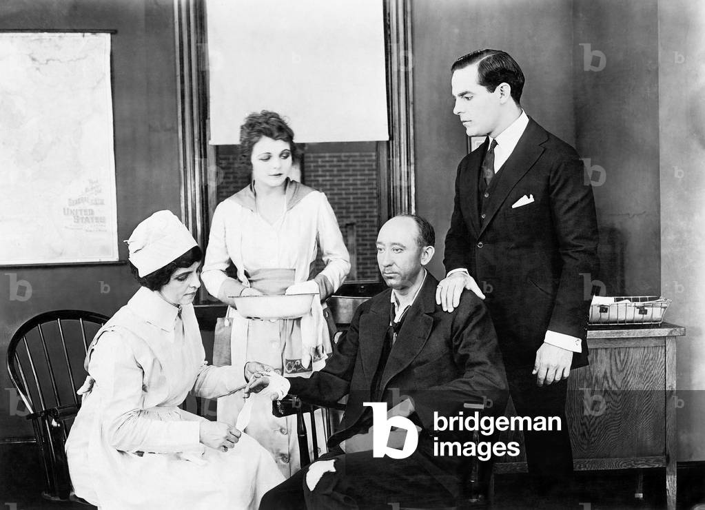 Patient and Two Nurses Attending Him and a Friend Comforting Him