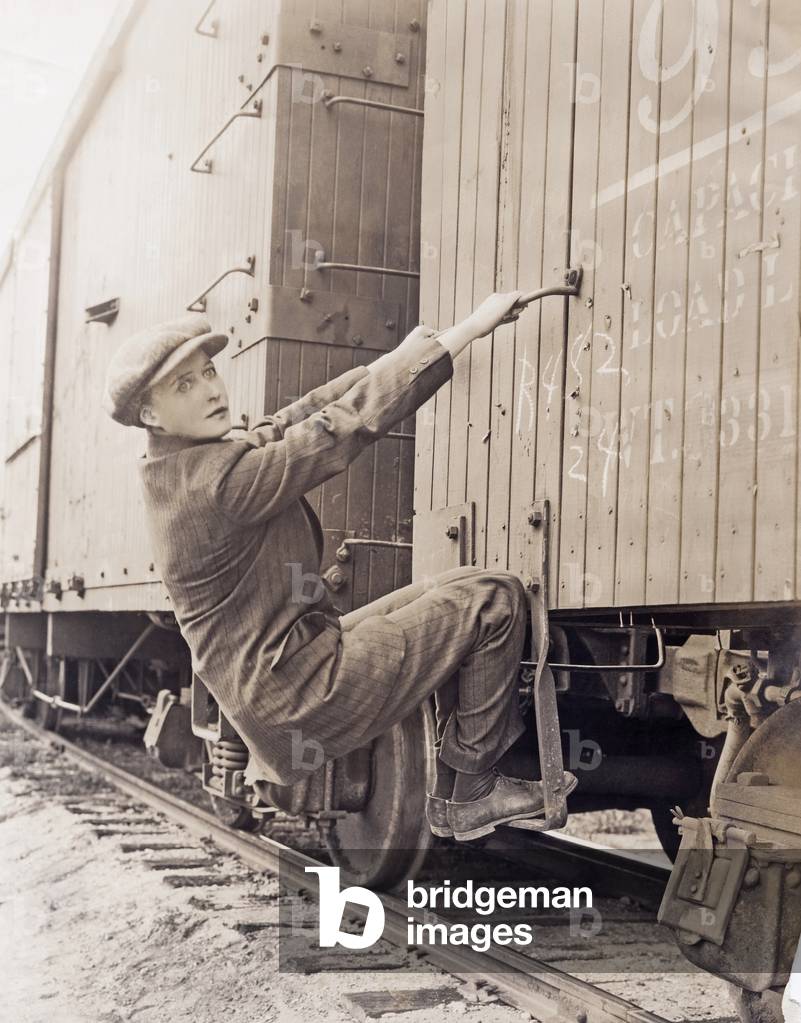 Female hobo climbing freight train (OLVI008_OU019_F)