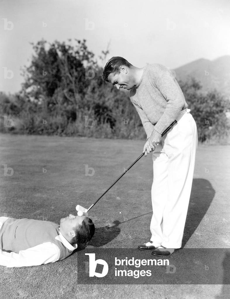 Man Hitting Golf Ball on Mans Forehead