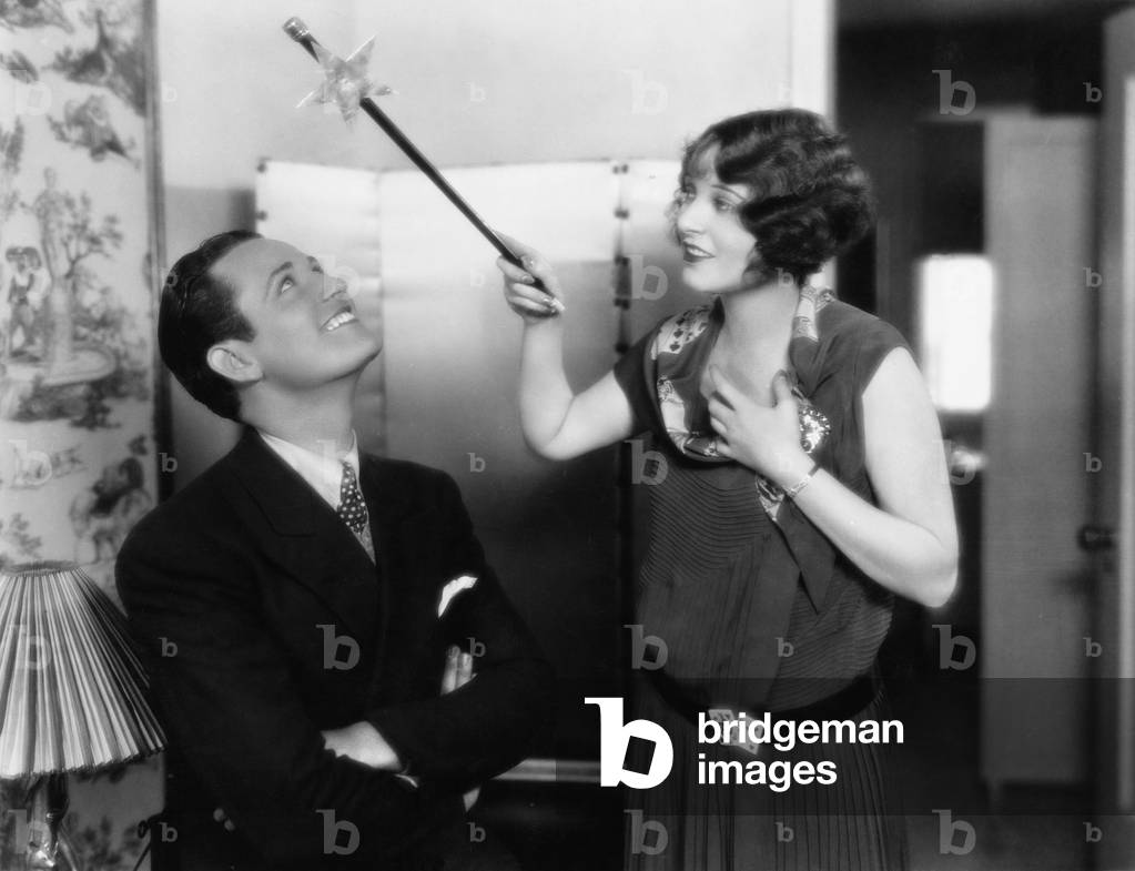 Woman Holding a Magic Wand Over her Friends Head