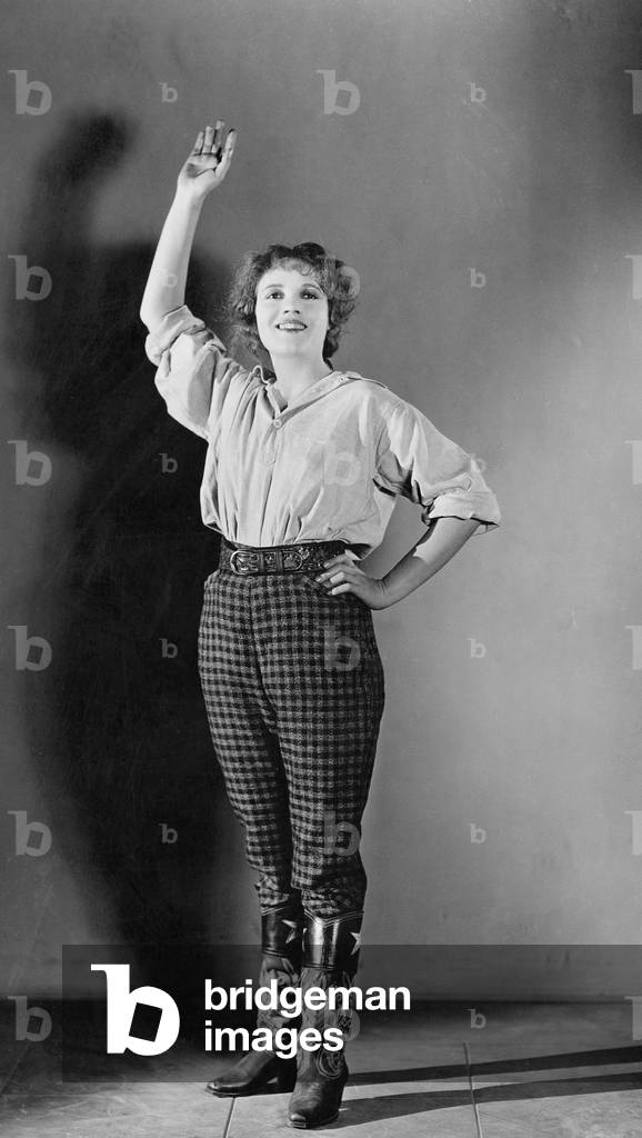 Young Woman Standing with her Hand Raised and Smiling