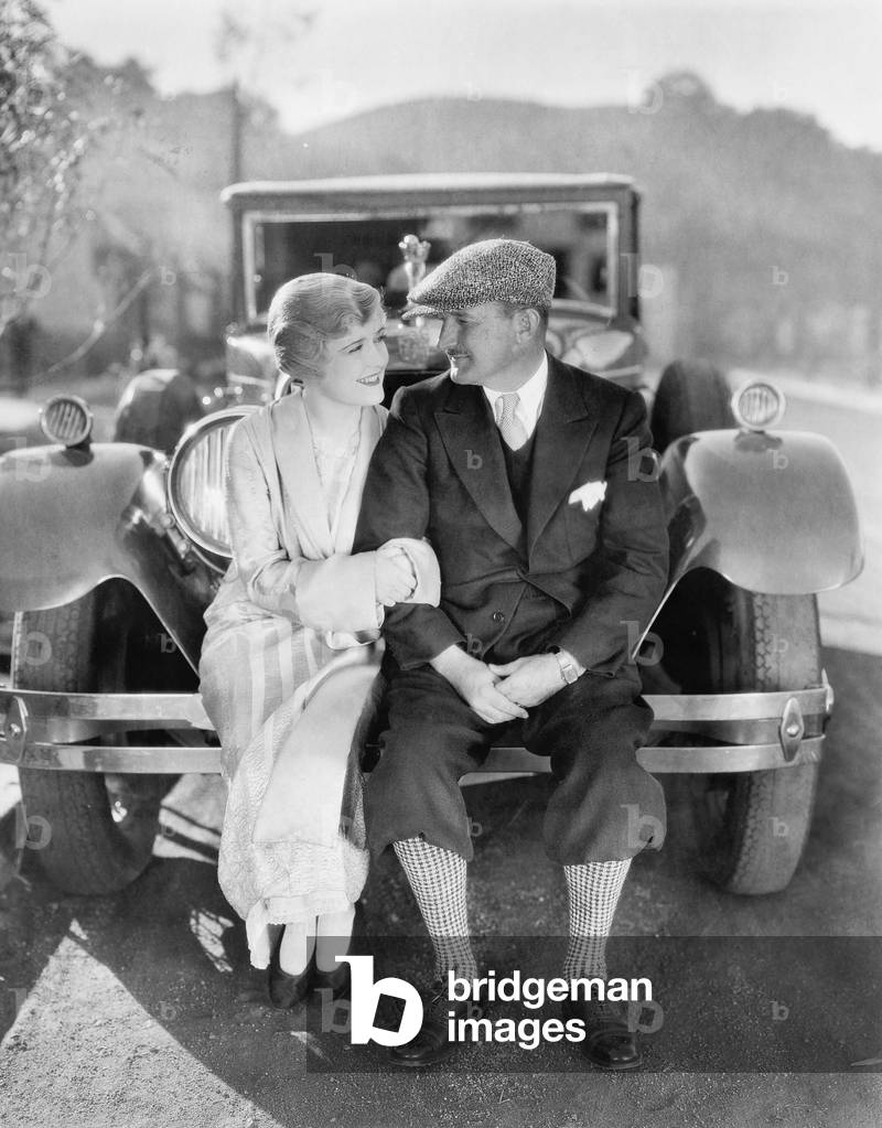 Couple Sitting Together on a Car Bumper