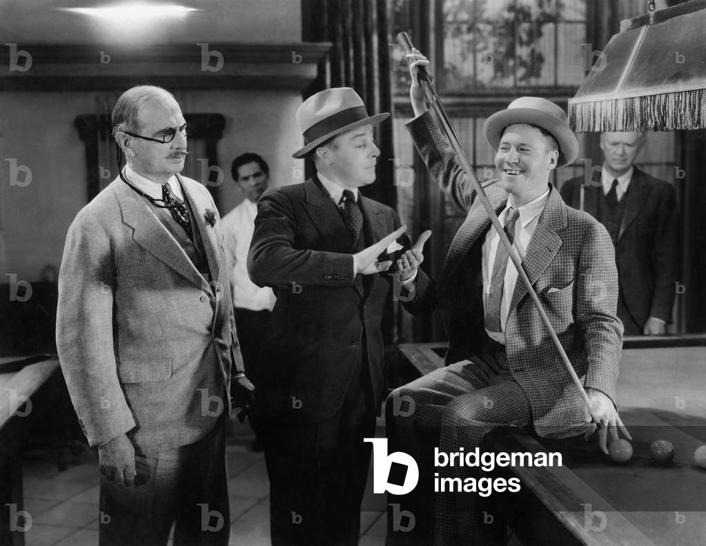 Two Men Talking to Each Other and a Man Standing Beside Them at a Pool Place