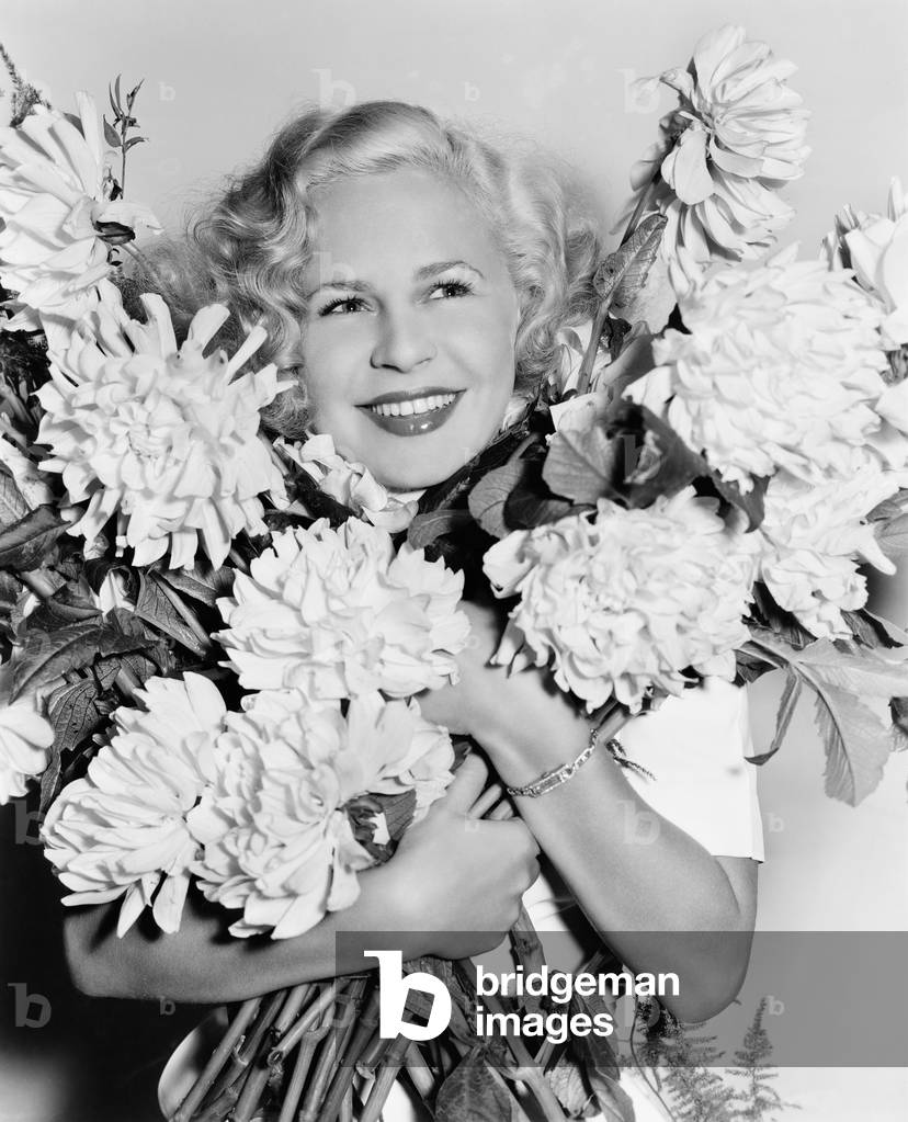 Portrait of a Young Woman Holding a Bunch of Flowers Looking Happy