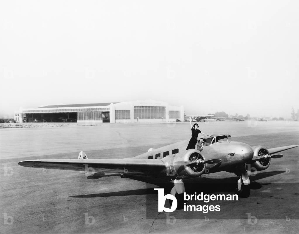 Woman Standing on the Propeller of an Airplane Waving
