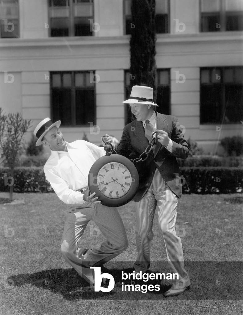 Two Men Wrestling with an Oversized Pocket Watch