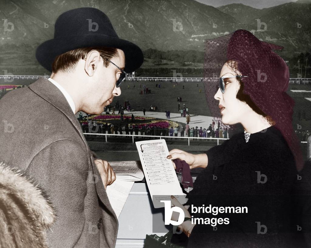 Elegant Couple at a Horse Race Looking at a Program