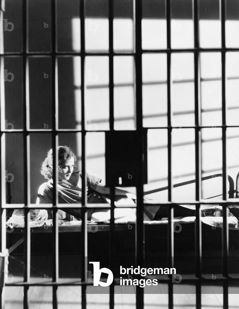 Woman Through Bars of Jail Cell