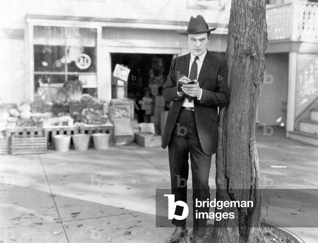 Detective Leaning Against Tree Taking Notes