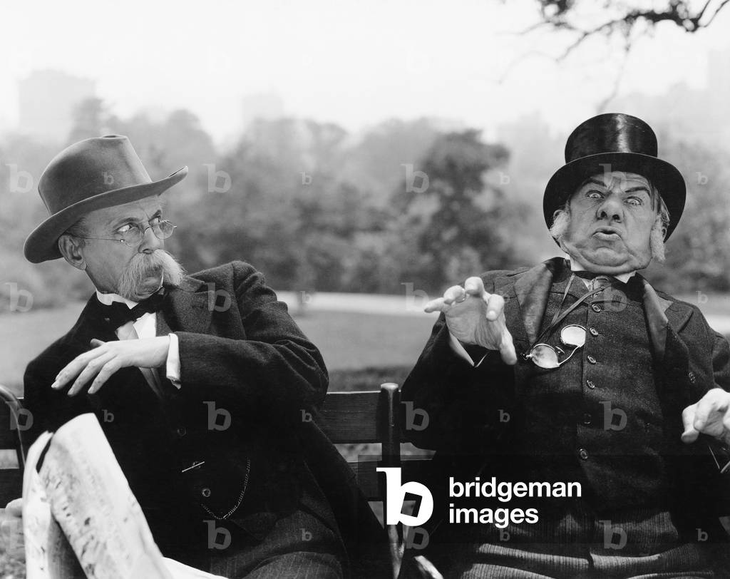 Two Men Sitting on a Bench Looking Shocked