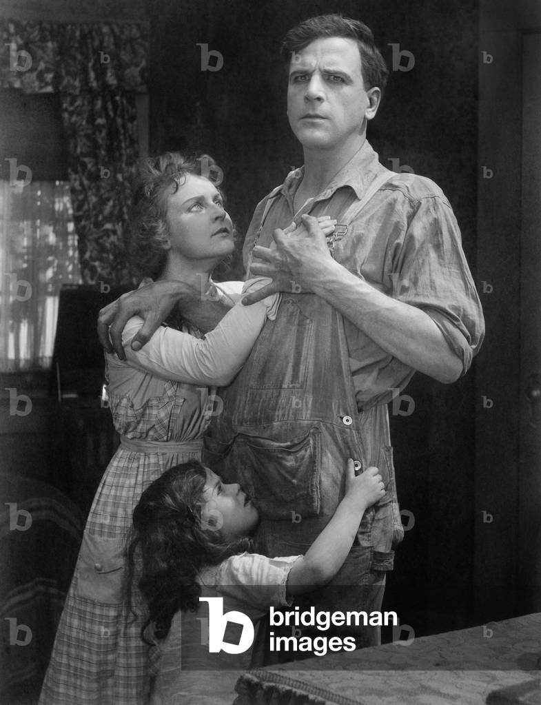 Couple Standing Embraced with Their Daughter