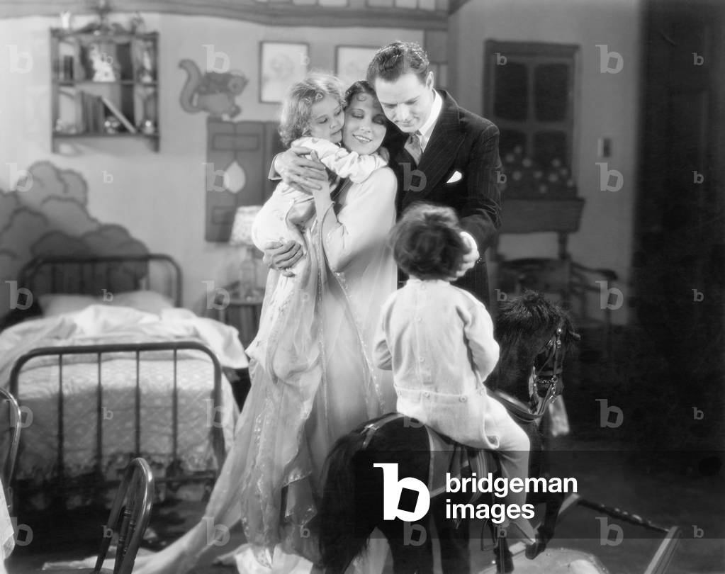 Family of Four Standing Together in a Child's Room
