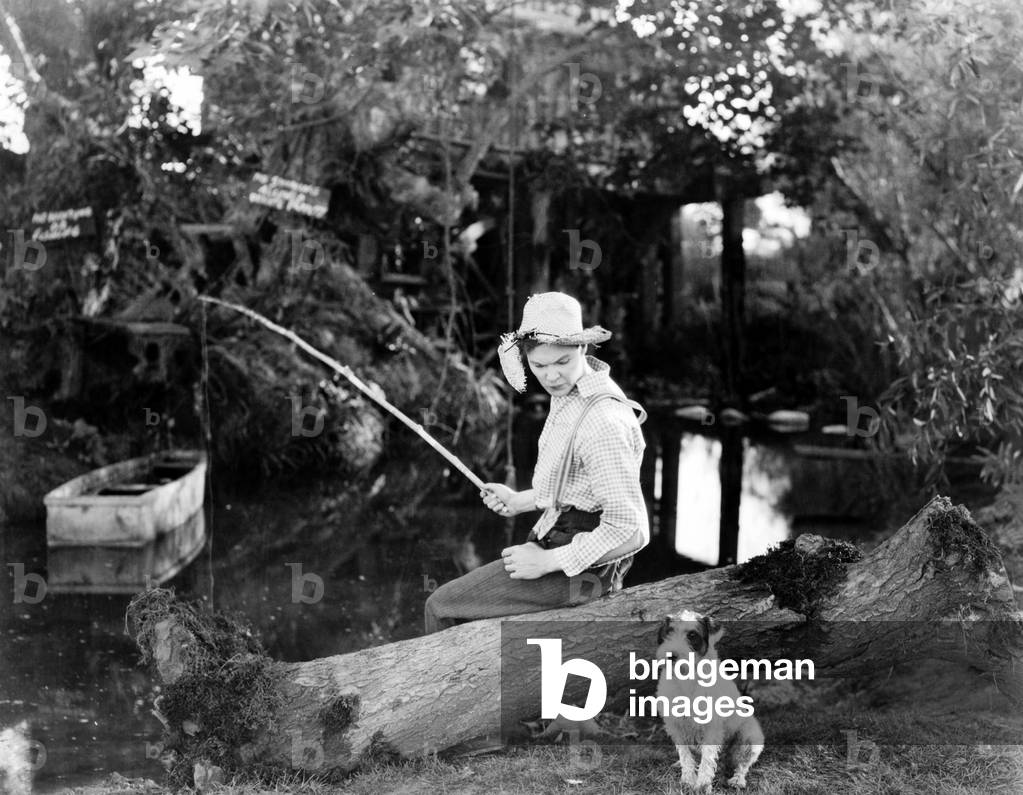 Un homme pechant en compagnie de son chien
