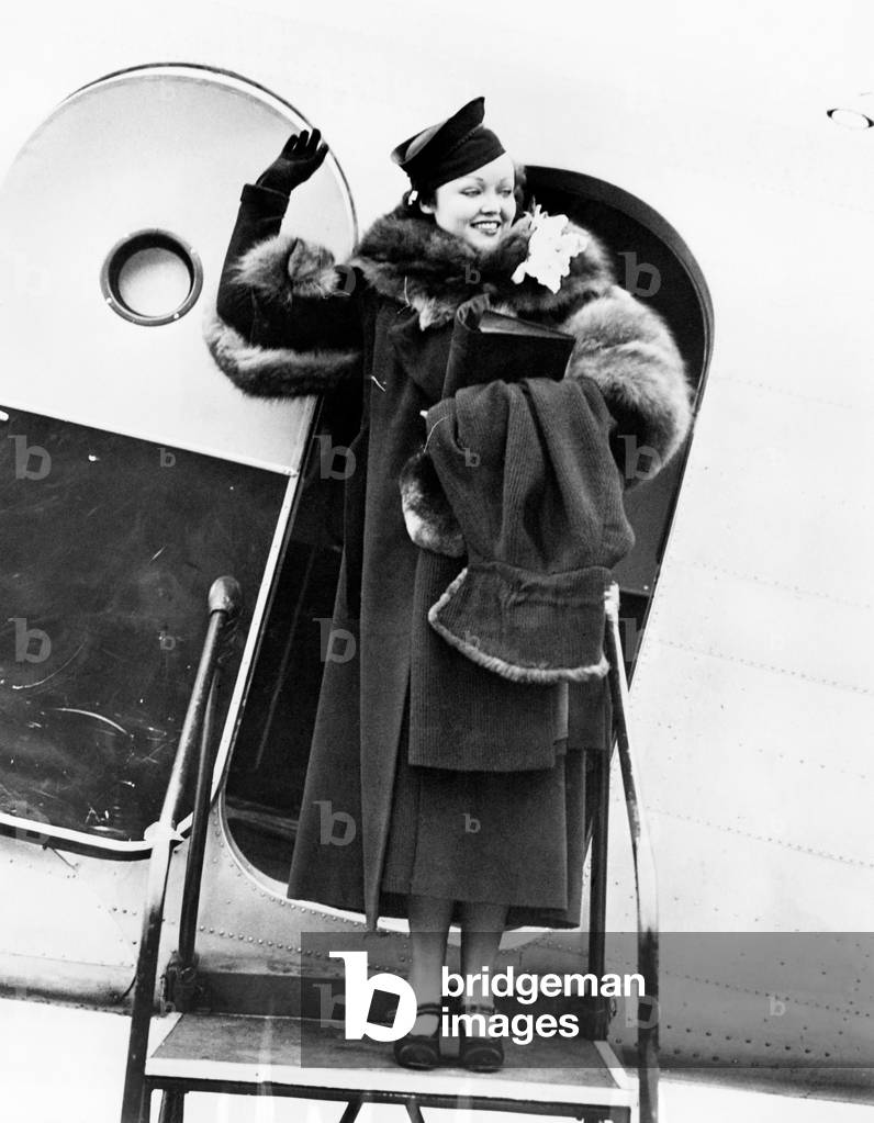 Elegant Woman Stepping Out of an Airplane and Waving