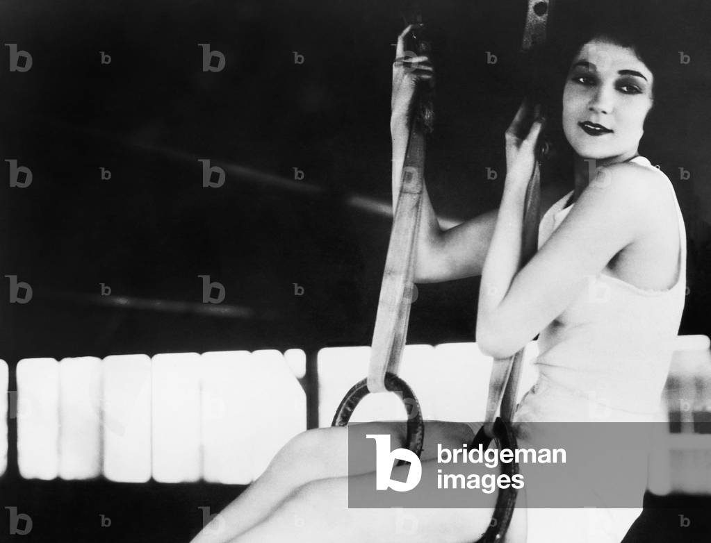 Profile of a Young Woman Swinging on Roman Rings