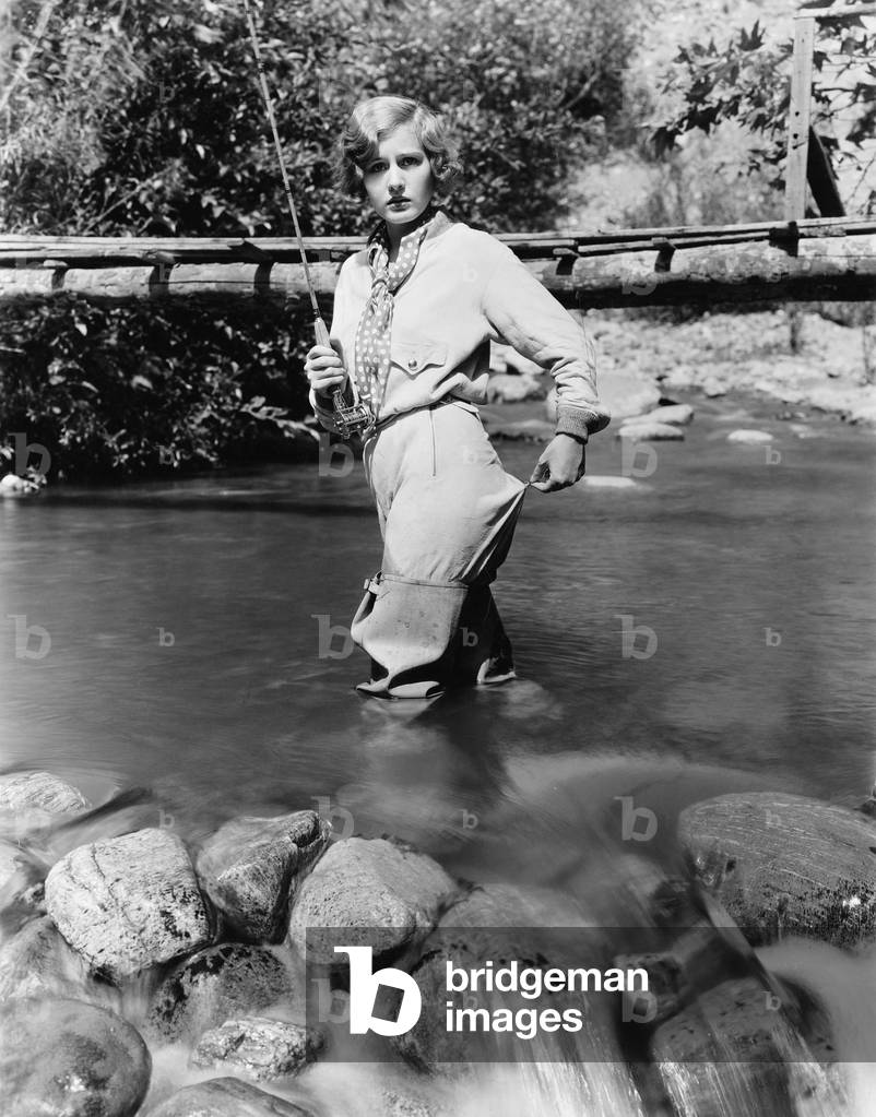 Woman with a Fishing Rod Standing in the Water
