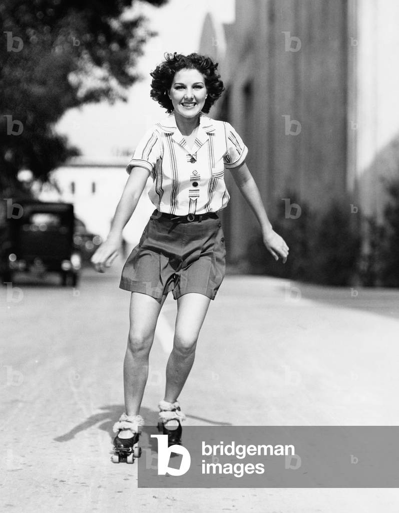 Portrait of a Young Woman Skating on the Road and Smiling