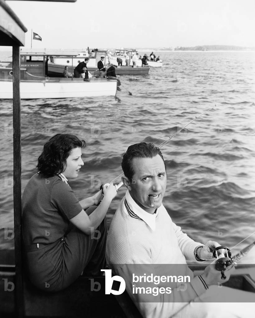 Man and Woman Sitting on a Boat on a Lake with Their Fishing Rod